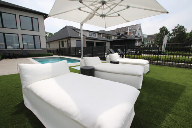 The private outdoor retreat offers beach access and includes a compact pool and comfortable white lounge chairs.