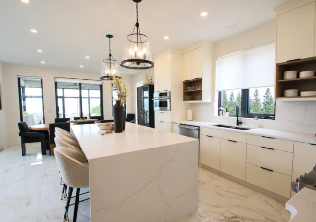 The kitchen has an open concept and blends clean modern design with functionality, featuring a waterfall island and warm natural finishes.
